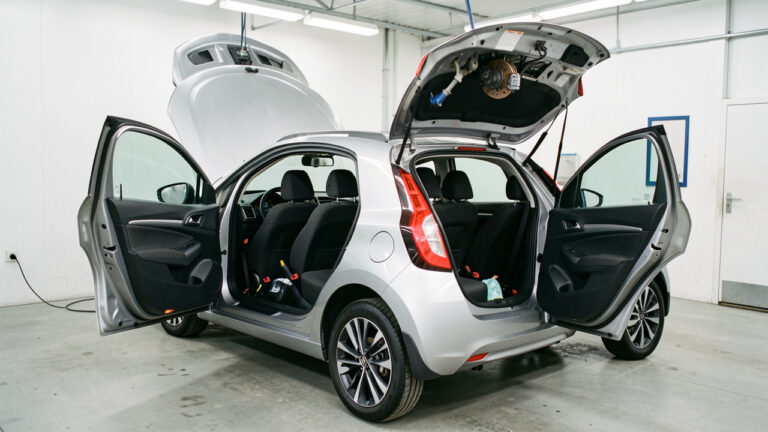 Inspection des équipements de sécurité d’une Renault Clio d’occasion, avec ceintures, airbags, appuie-têtes et éléments de freinage visibles.